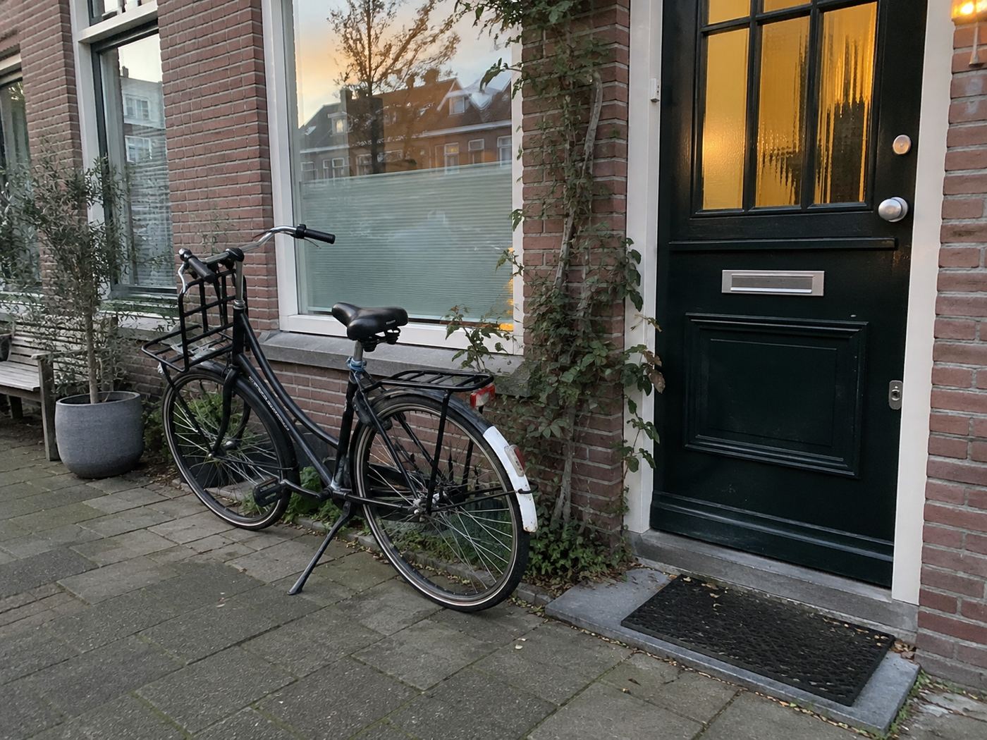Een fiets bij de voordeur in het avondlicht